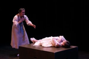 Juliet lies seemingly dead while Romeo looks on in anguish